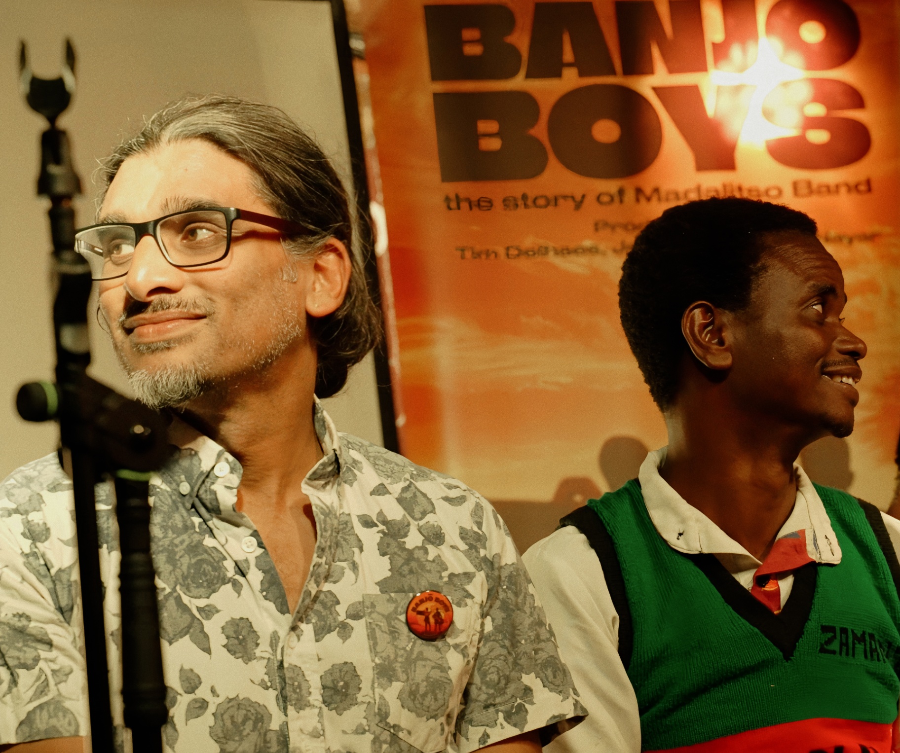 Johan Nayar beside The Banjo Boys poster at The Madalitso Experience at the Troubadour, London