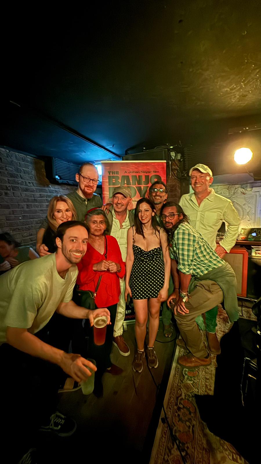 The La Femme Independent gang with Neil Nayar and his mum Sisty Nayar beside The Banjo Boys poster at The Madalitso Experience at the Troubadour, London