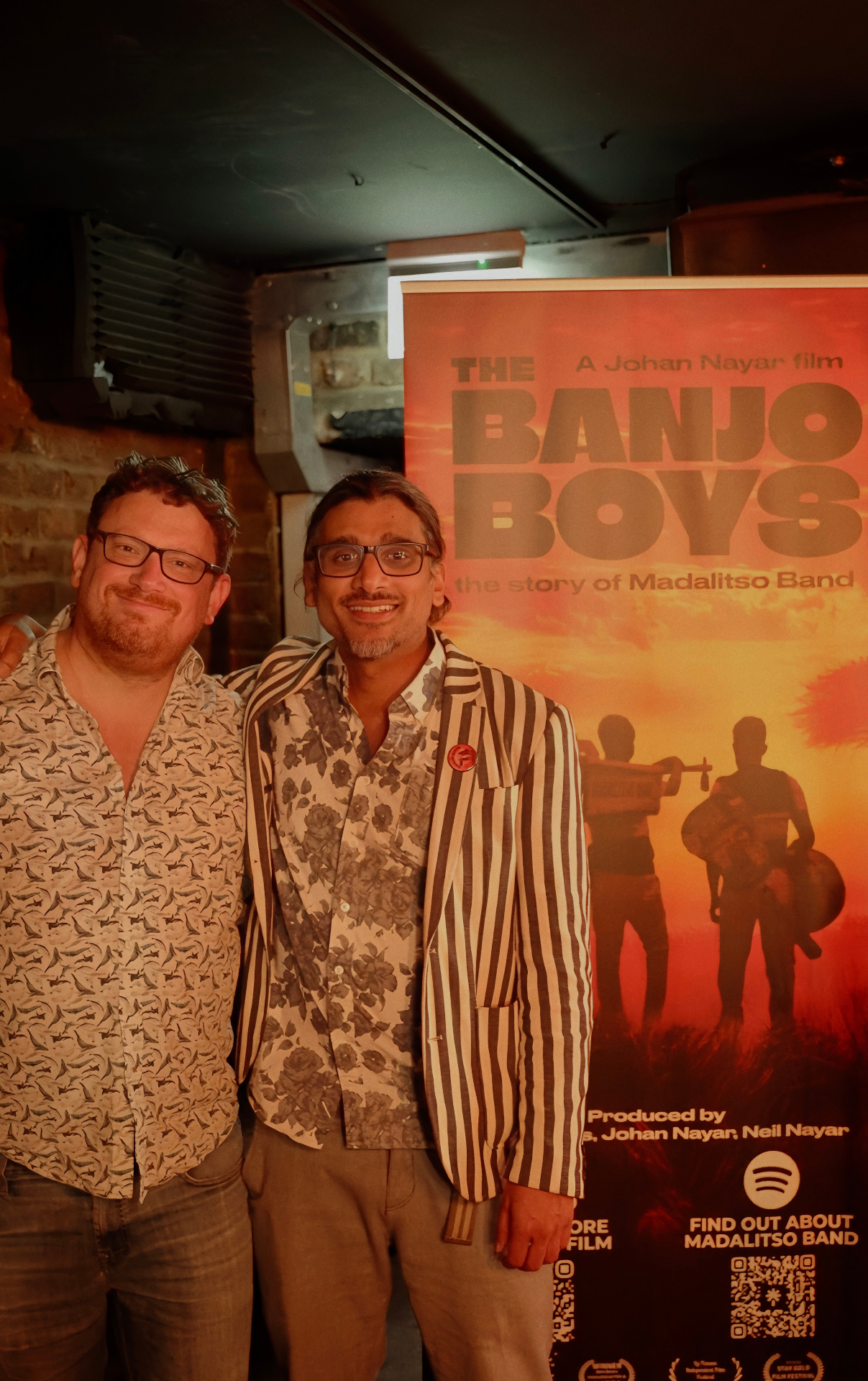 Chris Conder with Johan Nayar beside The Banjo Boys poster at The Madalitso Experience