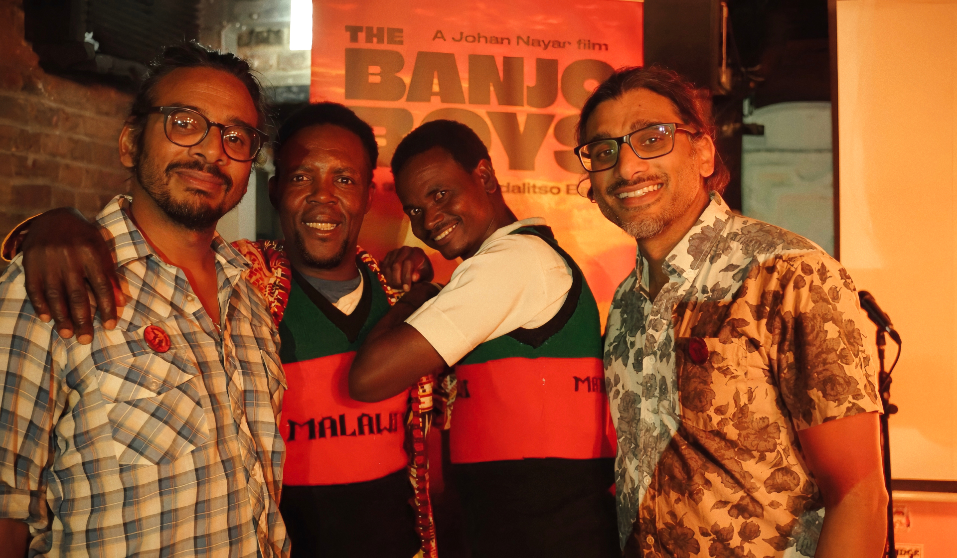 Director Johan Nayar with Madalitso Band in front of The Banjo Boys poster at the Troubadour, London — Neil Nayar, Yosefe Kalekeni, Yobu Maligwa and Johan Nayar (in that order)