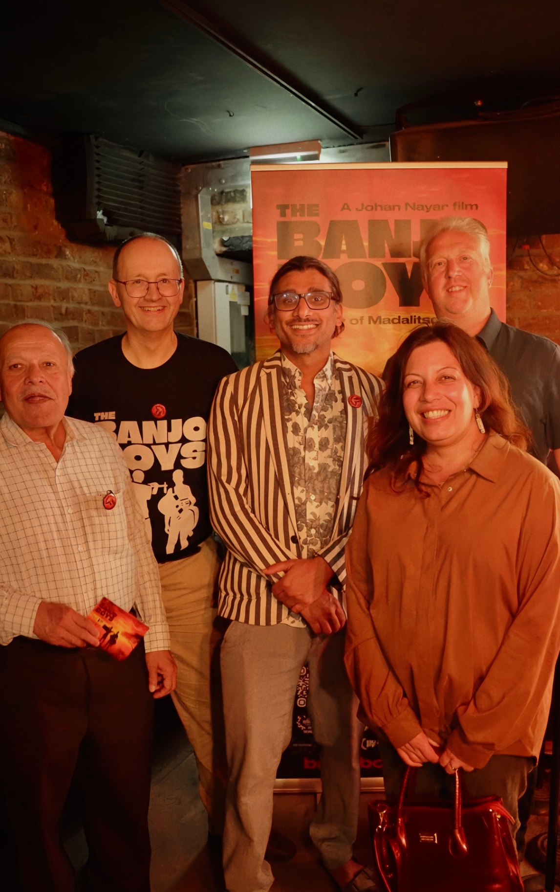 Mark Chandler and friends beside The Banjo Boys poster at The Madalitso Experience