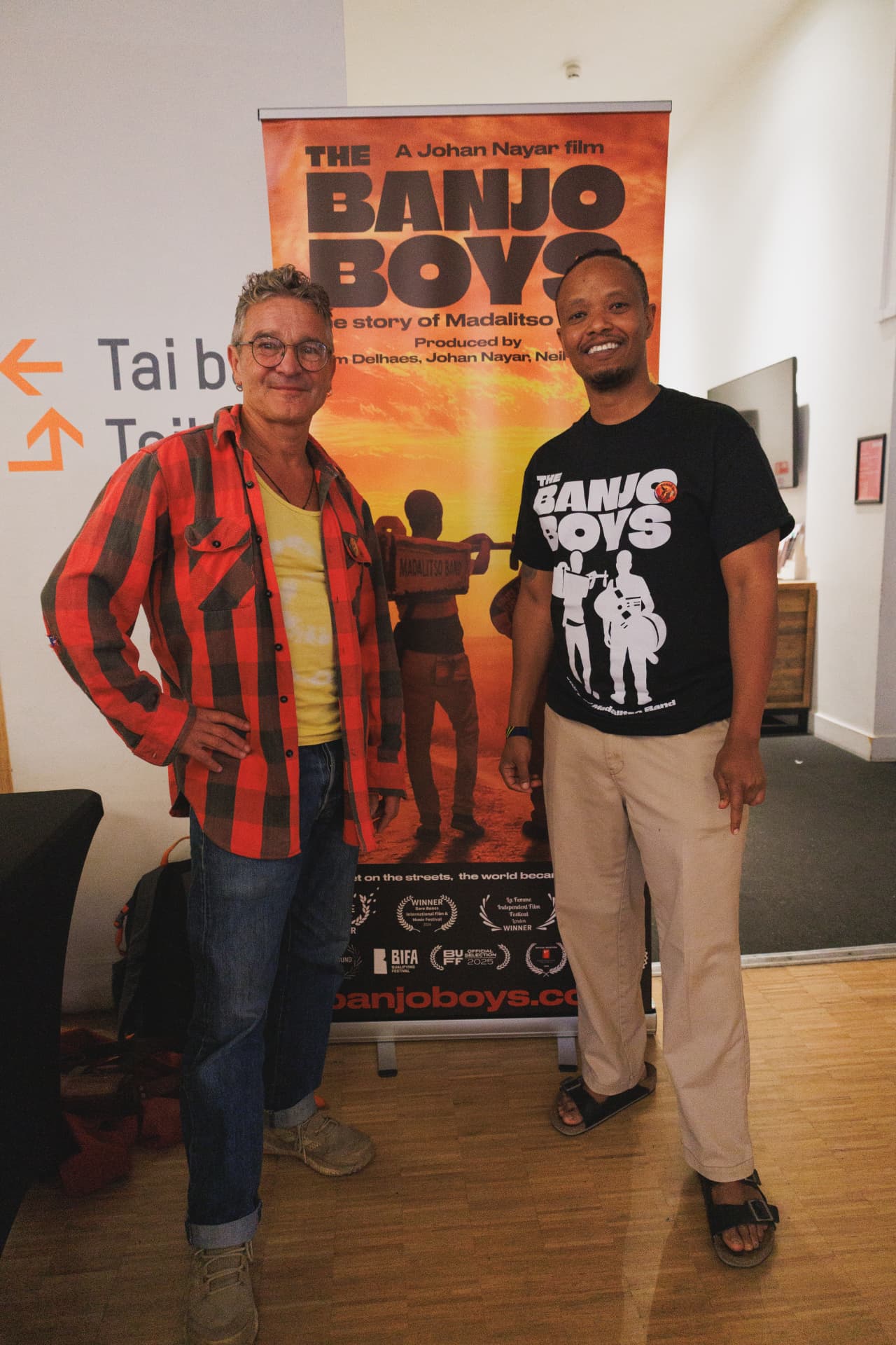 Tim Tyson Short and Fadhili Maghiya beside The Banjo Boys roll-up banner, Chapter Arts Centre, Cardiff