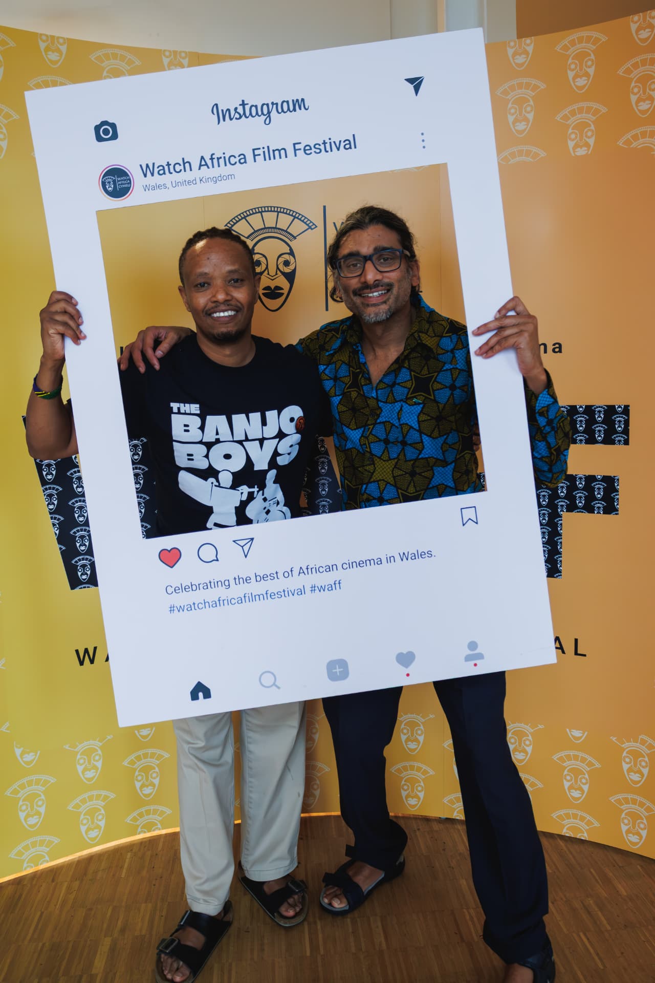 Fadhili Maghiya and Johan Nayar holding the Watch Africa Film Festival Instagram frame, Chapter Arts Centre, Cardiff