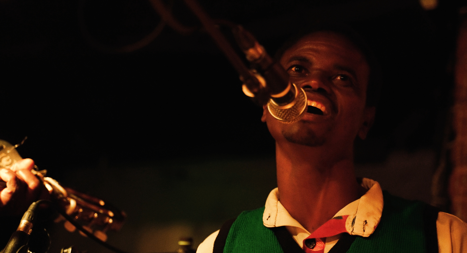 Yobu singing into the mic at The Madalitso Experience at the Troubadour, London — Yobu