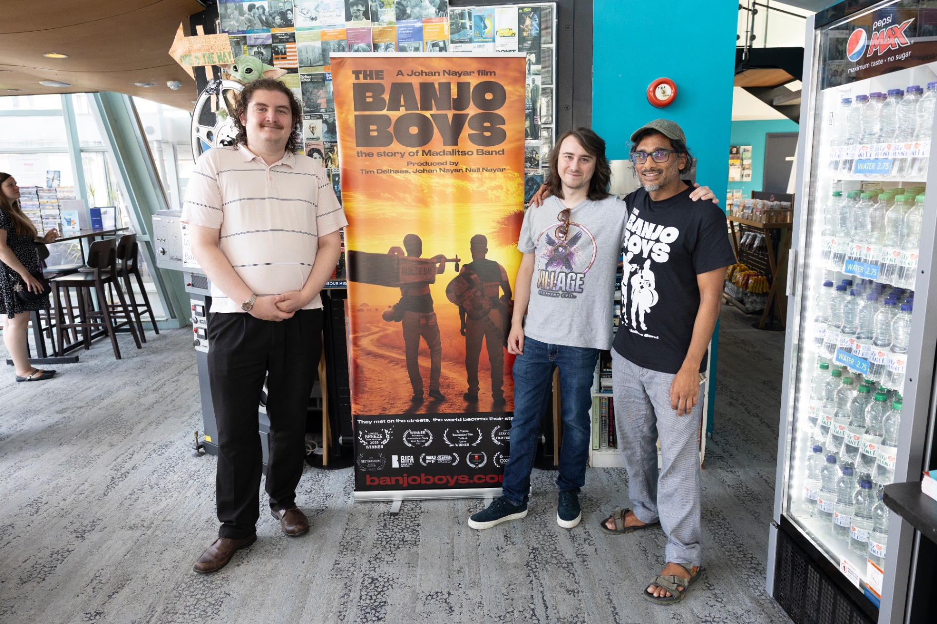 Johan Nayar with filmmaker Isaac Lawrence and Aaron beside The Banjo Boys poster at Harbour Lights, Southampton