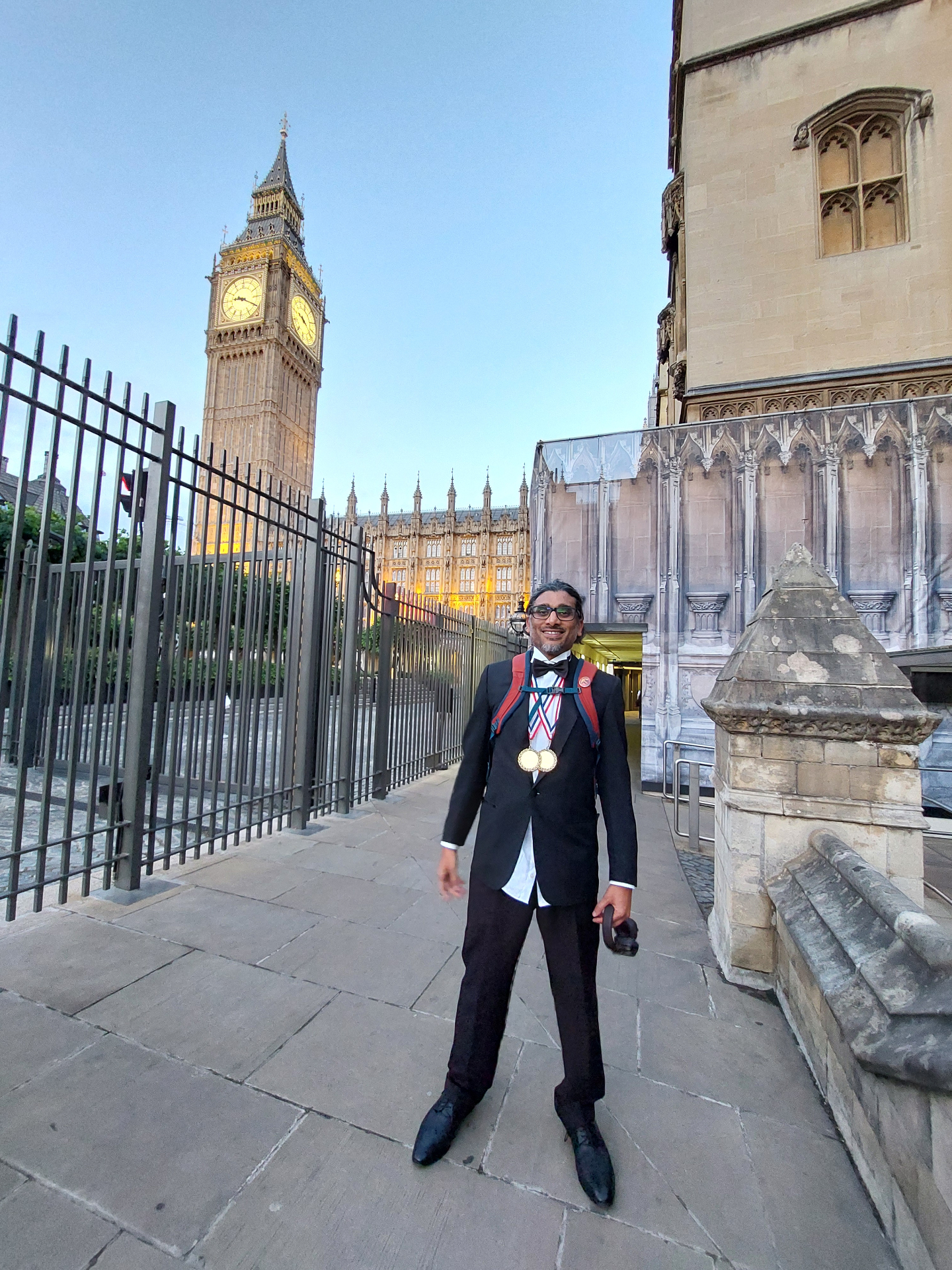 Johan Nayar outside the House of Lords with two awards
