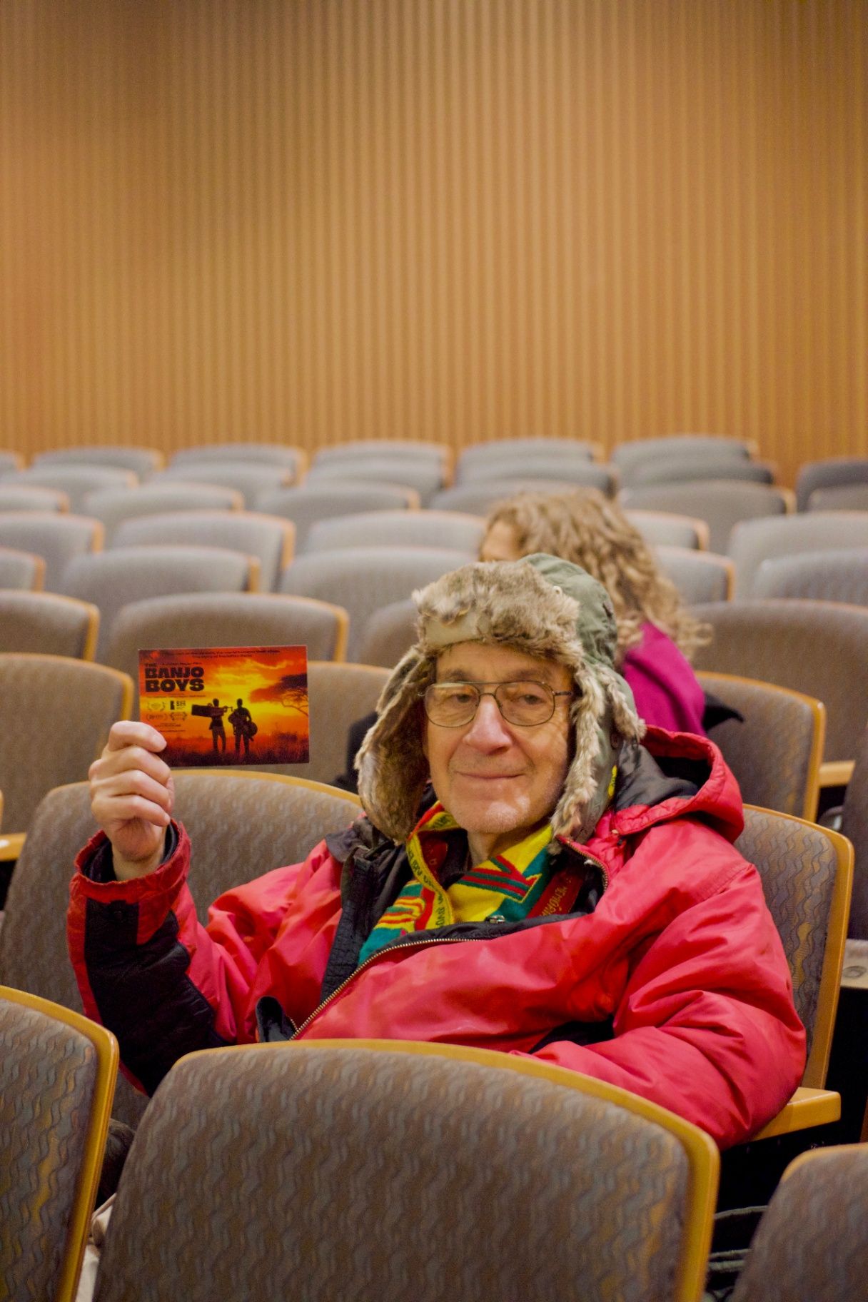 Audience member holding a Banjo Boys postcard before the ADIFF screening at Columbia University
