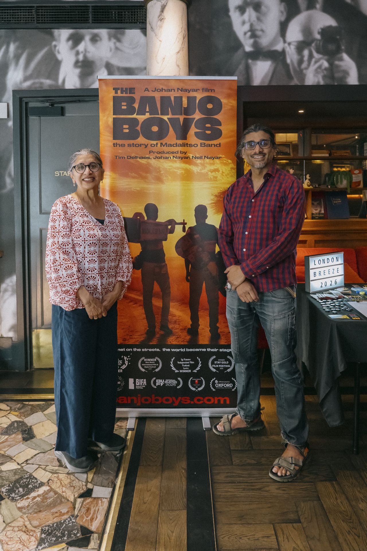 Guest with director Johan Nayar beside The Banjo Boys banner in the Bristol cinema foyer