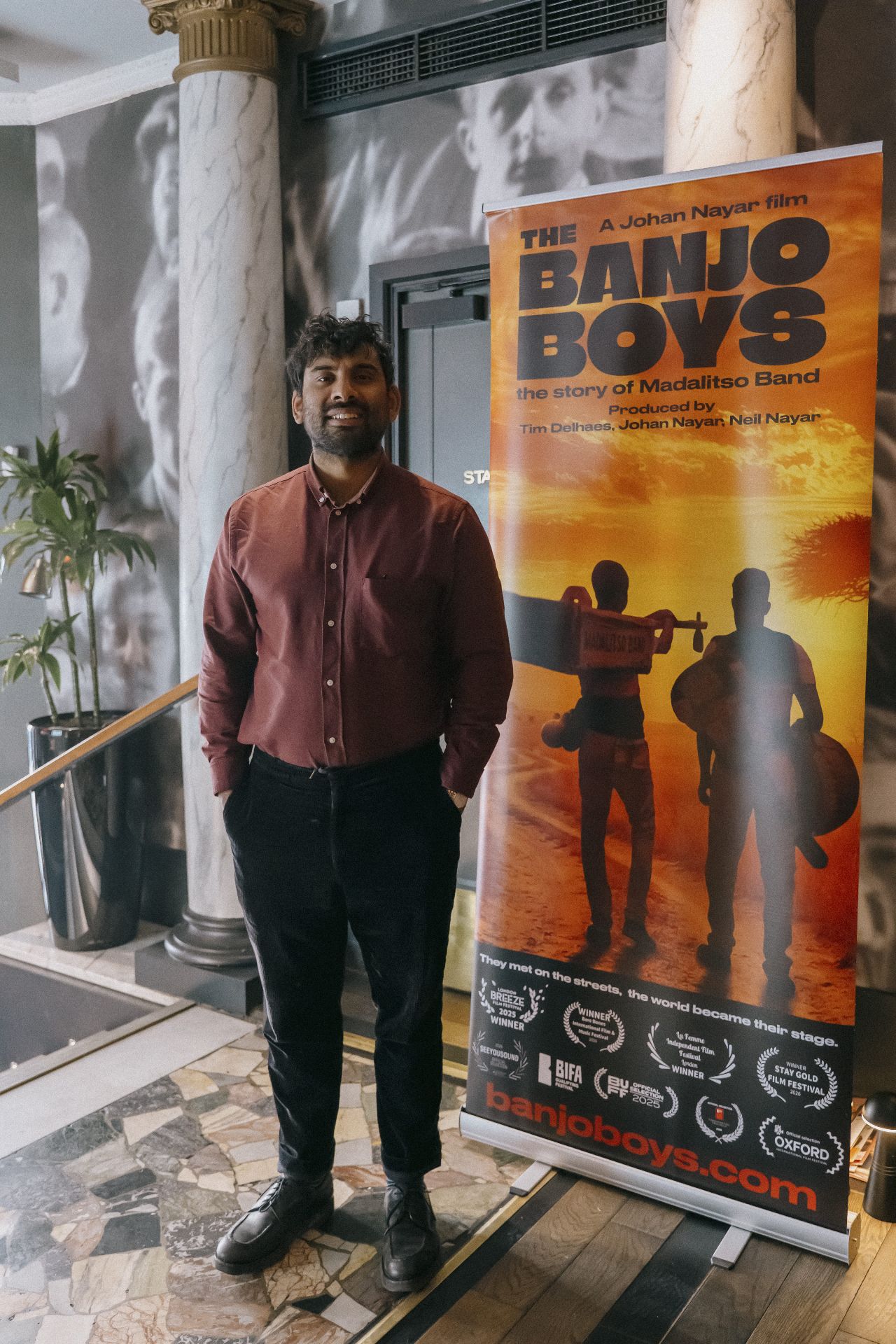 Guest posing beside The Banjo Boys banner in the Bristol cinema foyer