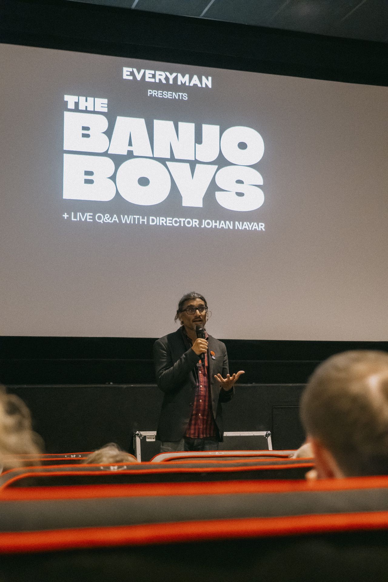 Director Johan Nayar introducing The Banjo Boys beneath the Everyman title card at Bristol