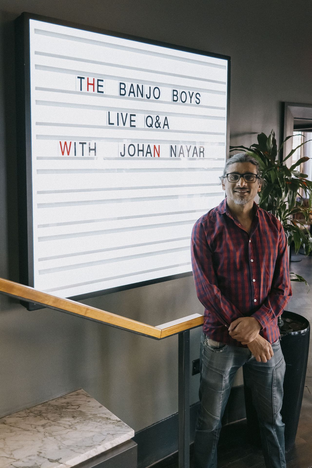 Director Johan Nayar beside The Banjo Boys Live Q&A lightbox sign in Bristol
