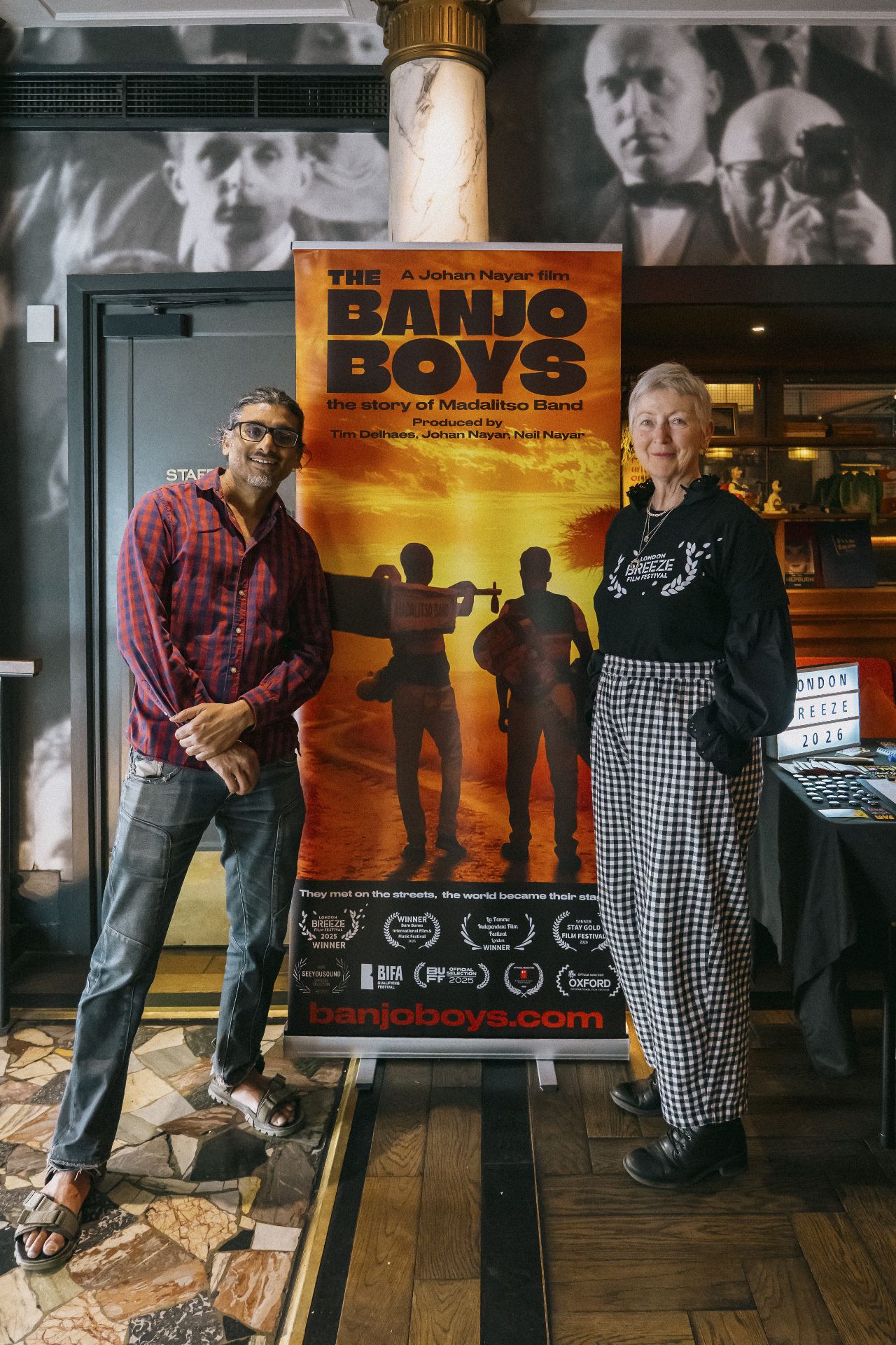 Director Johan Nayar with London Breeze Film Festival's Madeleine Casey beside The Banjo Boys banner in Bristol