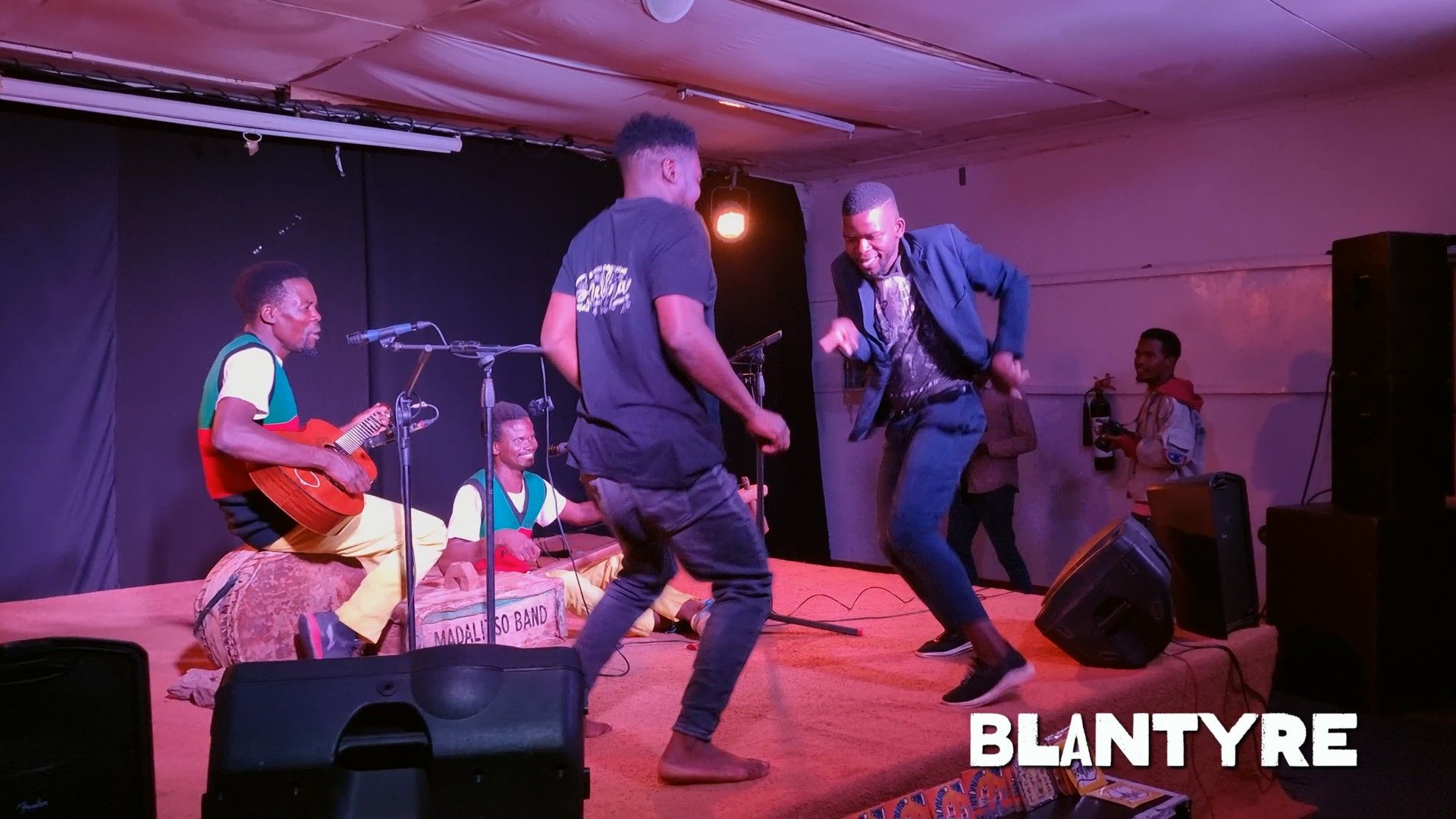 The sound men can't hold back and get on stage during a Madalitso Band show in Blantyre, 2023