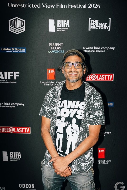 Director Johan Nayar in his Banjo Boys t-shirt on the Unrestricted View Film Festival 2026 step-and-repeat